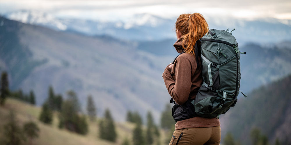 Woman looking off into the distance with hiking gear on